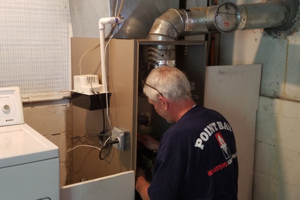 Point Bay Fuel HVAC technician inspecting furnace on a work site