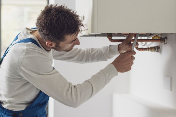 Professional technician checking a boiler and pipes depicting boiler maintenance