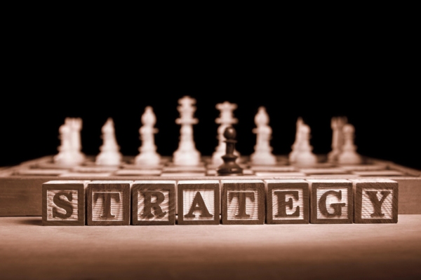 Strategy spelled using wooden blocks in front of chess pieces depicting for Enhancing Air Conditioner Efficiency