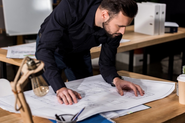 architect looking at building blueprint depicting transformation in architectural design