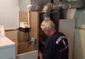 Point Bay Fuel HVAC technician inspecting furnace on a work site