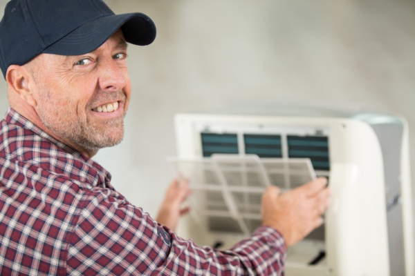 man inspecting portable air conditioner