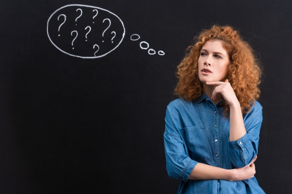 redhead girl with question marks as thought bubble depicting frequently asked questions