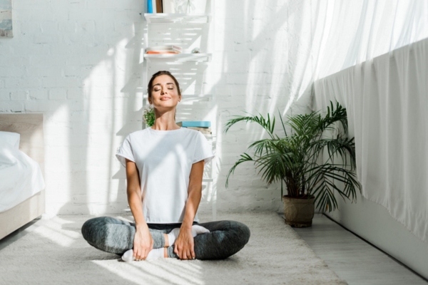 woman meditating in the morning depicting good indoor air quality