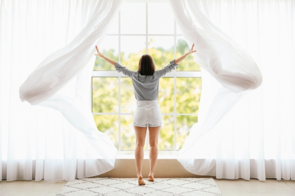 woman opening window for natural cooling during summer