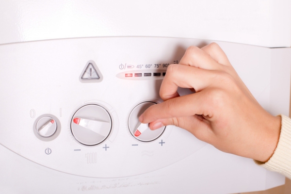 woman turning on boiler at home depicting boiler efficiency